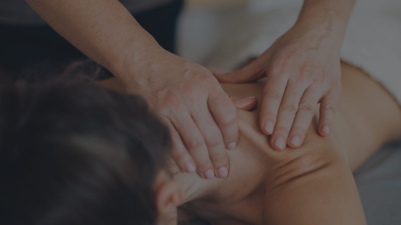 Therapist performing a shoulder massage on a client to relieve pain and stress.