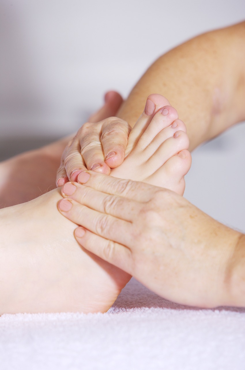 “Therapist in Hialeah performing reflexology on a client’s feet at Massage Me massage business”